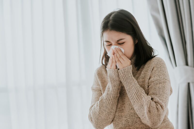 woman sneezing due to poor indoor air quality