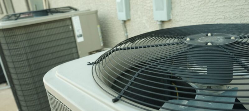 a picture of two outdoor HVAC units next to each other at the side of a home